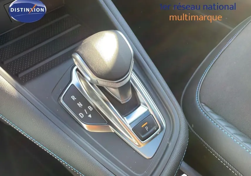 Le levier de vitesse automatique du Renault Captur E-Tech hybride 2025, avec surpiqûres bleues sur la console noire.