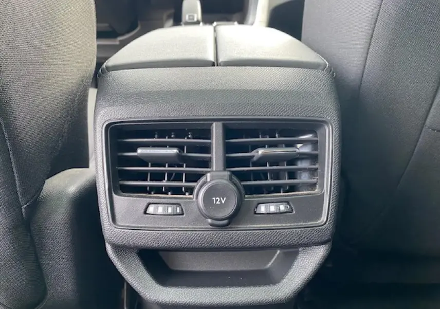 Vue rapprochée des aérateurs arrière et prise 12V entre les sièges avant d'un Peugeot 3008 gris platinium.