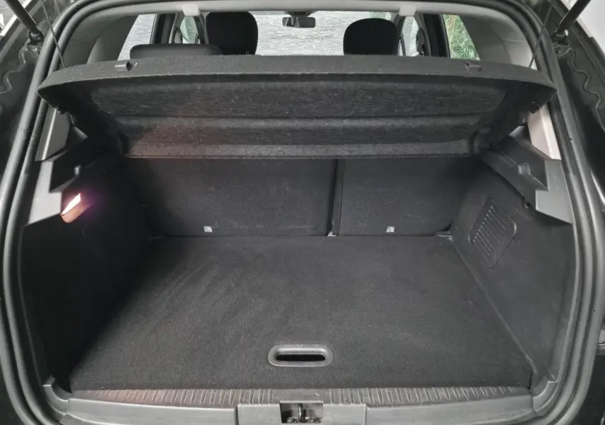 Coffre ouvert du Renault Captur noir 2014, vue arrière montrant le plancher plat et la tablette cache-bagages relevée.