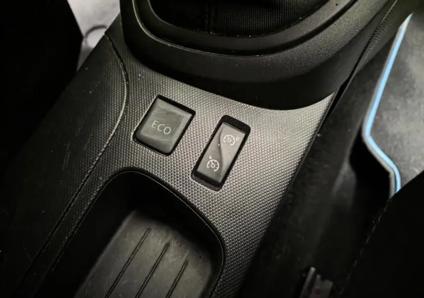 Gros plan sur les boutons Eco et régulateur de vitesse dans la console centrale noire du Renault Captur 2014.