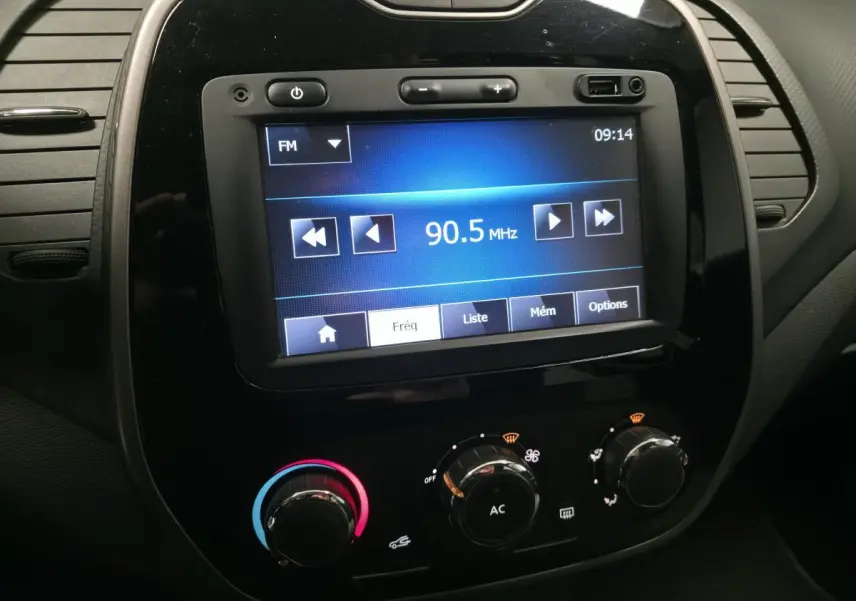 Gros plan sur la console centrale noire du Renault Captur 2014 avec écran tactile MediaNav et commandes de climatisation.