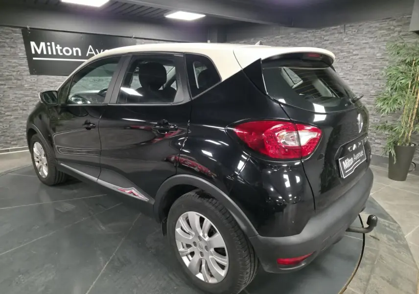 Renault Captur noir vue 3/4 arrière droit avec attelage et jantes alliage 16 pouces dans showroom.
