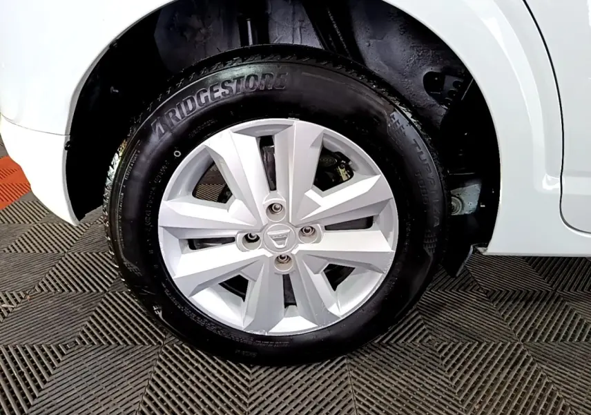 Gros plan sur la roue avant droite blanche d'une Dacia Sandero 2022 avec jante en alliage et pneu Bridgestone.