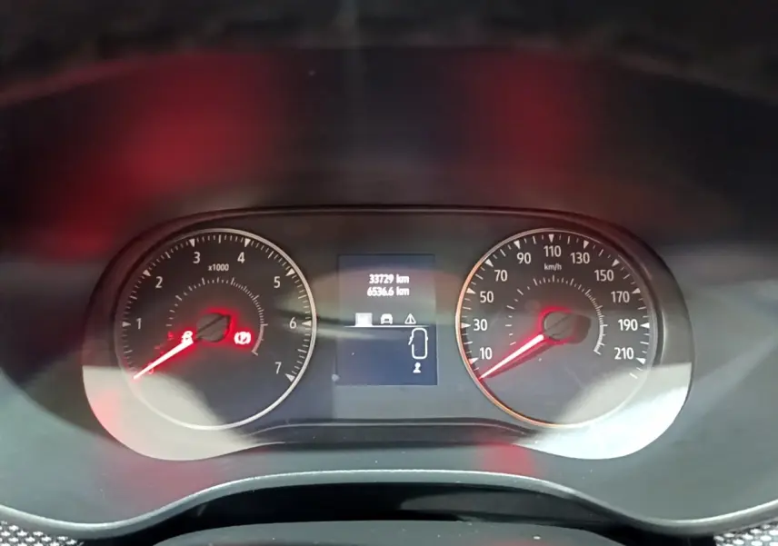 Vue rapprochée du tableau de bord du Dacia Sandero blanc 2022, affichant compte-tours, vitesse et écran multifonctions.