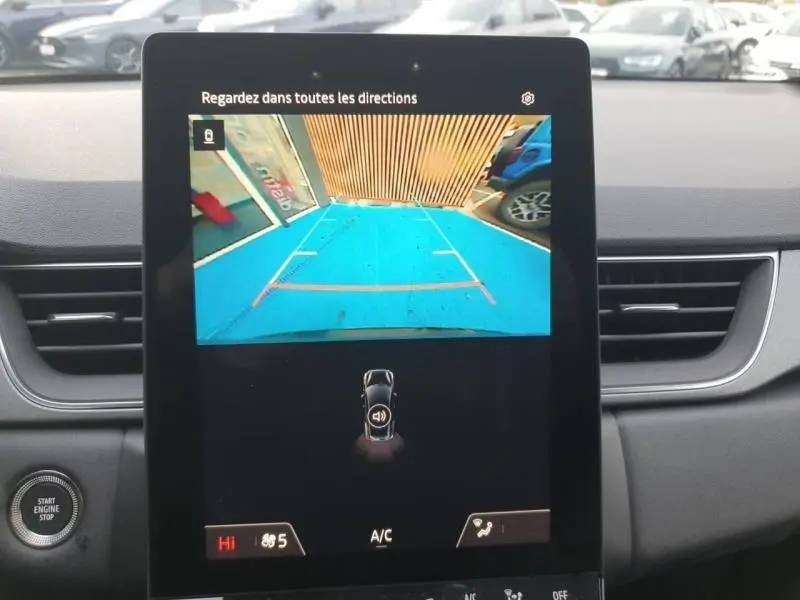 Écran tactile intérieur montrant la caméra de recul avec vue panoramique du stationnement arrière du Renault Captur gris Cassiopée.