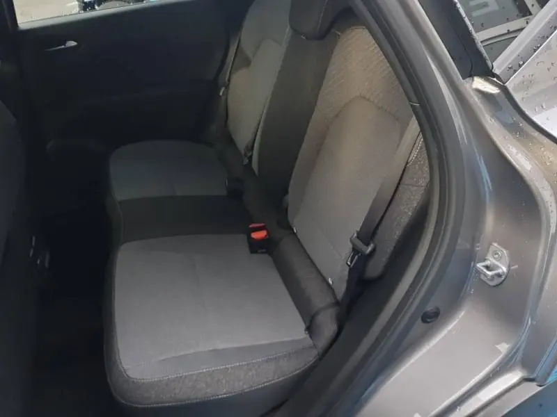 Vue intérieure arrière droite du Renault Captur 1.6 E-Tech gris Cassiopée, banquette tissu 3 places avec ceintures visibles.