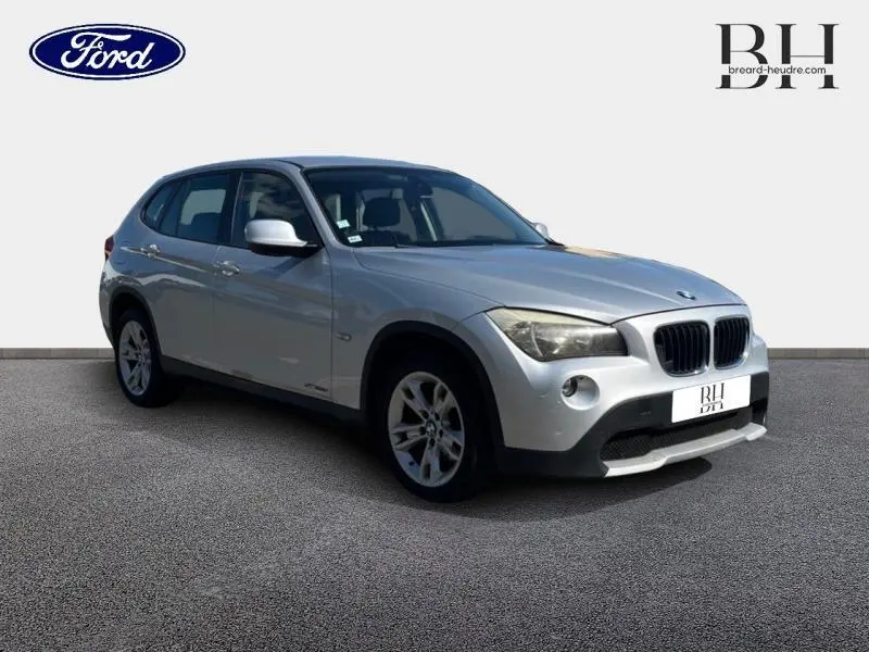 BMW X1 sDrive18d gris métallisé vue 3/4 avant droit avec jantes alu 17 pouces et calandre caractéristique.