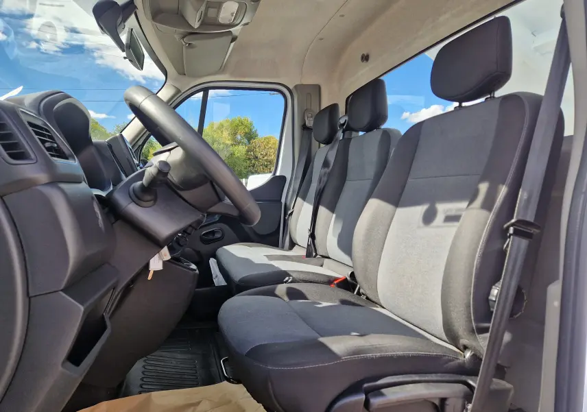 Vue intérieure côté conducteur du Renault Master Châssis Cabine 2024, montrant les sièges gris et le volant noir.