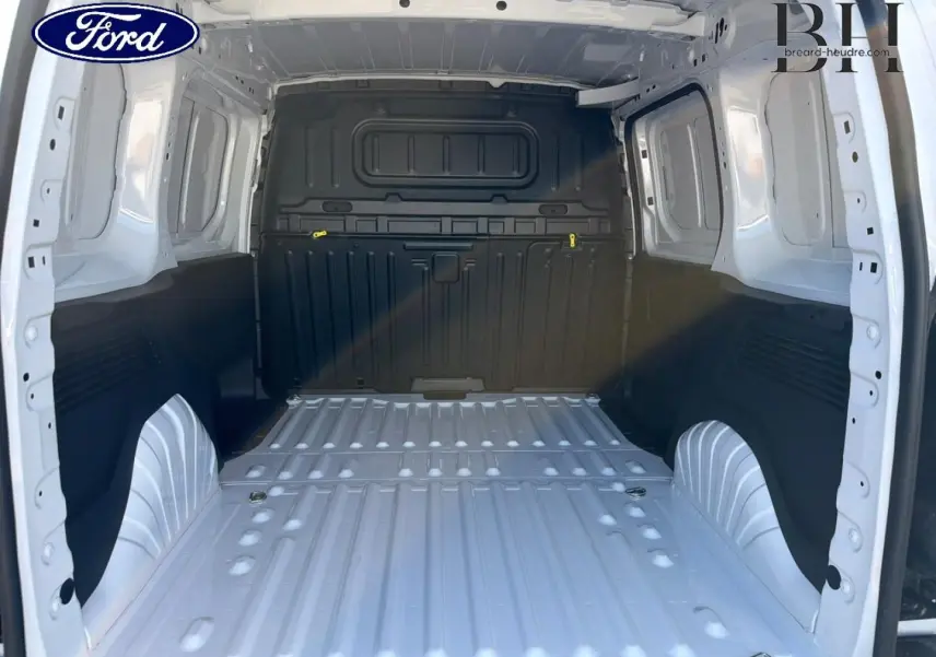 Vue intérieure arrière du coffre blanc Icy du Peugeot Partner 2025, montrant l'espace de chargement vide et la cloison pleine noire.