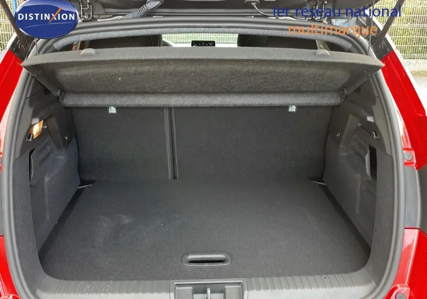 Coffre ouvert du Renault Captur E-Tech hybride rouge passion avec toit noir, vue arrière montrant l'espace de chargement.