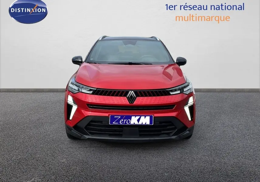 Vue frontale du Renault Captur E-Tech Hybrid 2025 rouge passion avec toit noir, éclairage LED distinctif allumé.