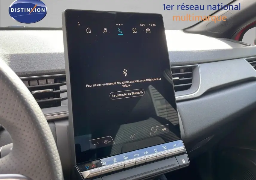 Écran tactile central du tableau de bord du Renault Captur E-Tech rouge, avec commandes climatisation visibles.