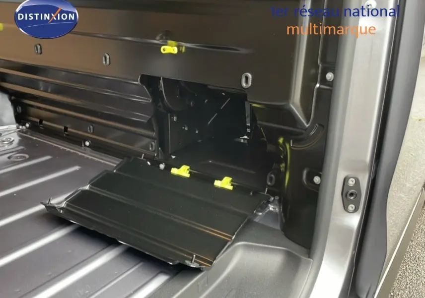 Détail intérieur du coffre côté droit du Citroën Jumpy gris Artense, montrant un compartiment de rangement ouvert.