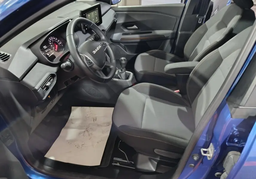 Vue intérieure côté conducteur de la Dacia Sandero Extreme+ 2024 bleu, volant cuir multifonctions et tableau de bord digital.