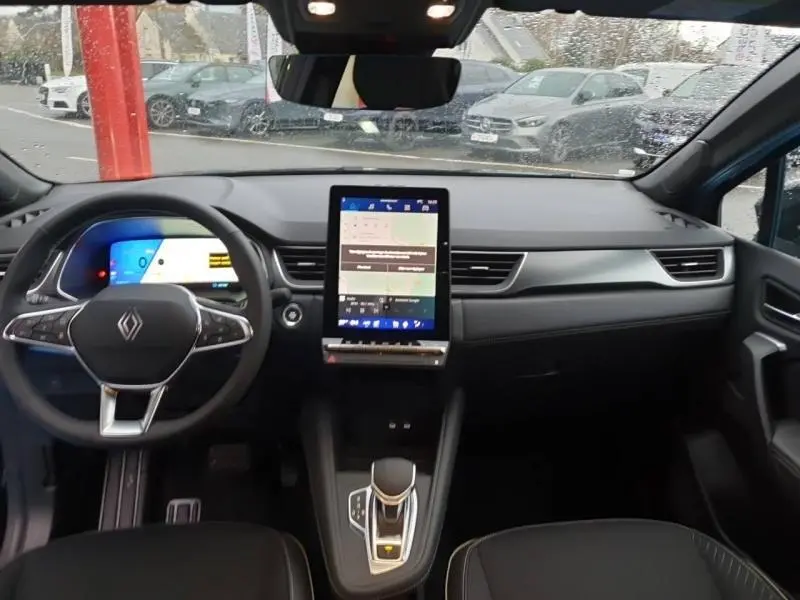 Vue intérieure avant du tableau de bord noir étoilé du Renault Symbioz 2025 avec écran tactile vertical et volant multifonction.
