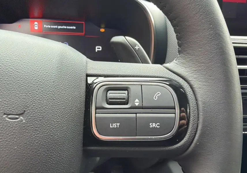 Gros plan sur les commandes multifonctions à droite du volant cuir du Citroën C5 Aircross Hybrid 2025.