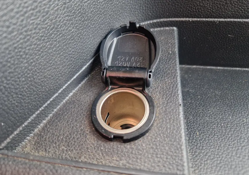 Prise allume-cigare 12V ouverte sur la console intérieure noire du Renault Master Châssis Cabine blanc 2024.