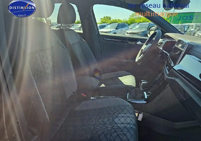 Intérieur du Volkswagen T-Roc 2025 en tissu noir R-Line, vue côté droit sur sièges avant et tableau de bord.