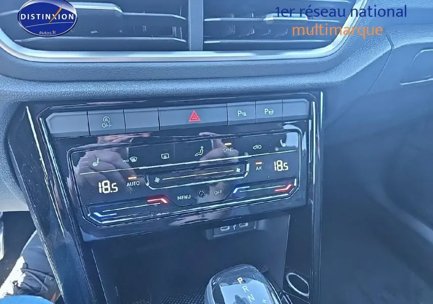 Console centrale avec commandes climatisation bi-zone et levier de boîte automatique dans un Volkswagen T-Roc noir perle 2025.