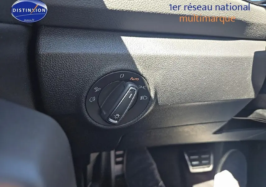 Gros plan sur l'interrupteur des phares du Volkswagen T-Roc noir perle, côté gauche du tableau de bord.