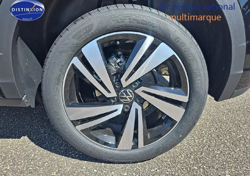 Gros plan sur la jante alliage 18 pouces Nevada noir du Volkswagen T-Roc noir perle, avec logo VW central visible.