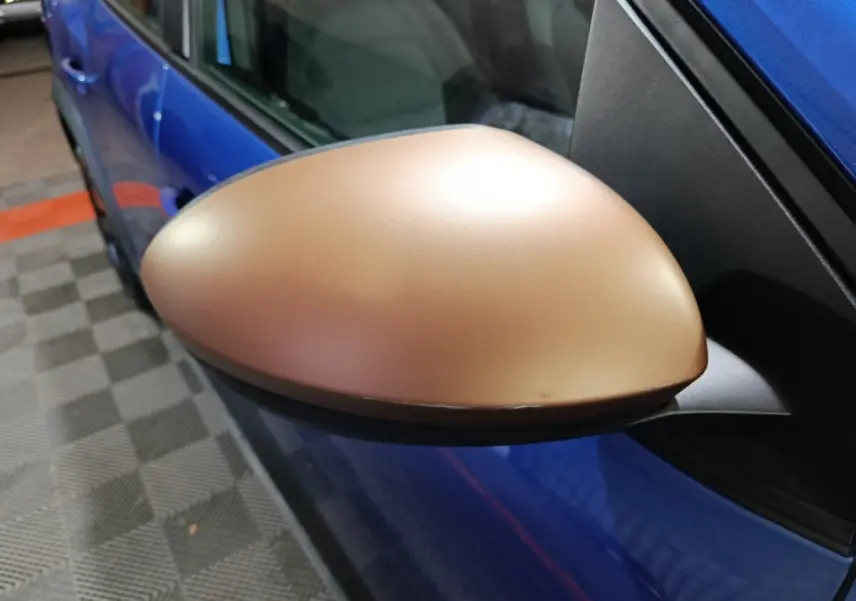 Rétroviseur droit bronze sur Dacia Sandero Extreme+ TCe 110 bleu, vue rapprochée côté conducteur.