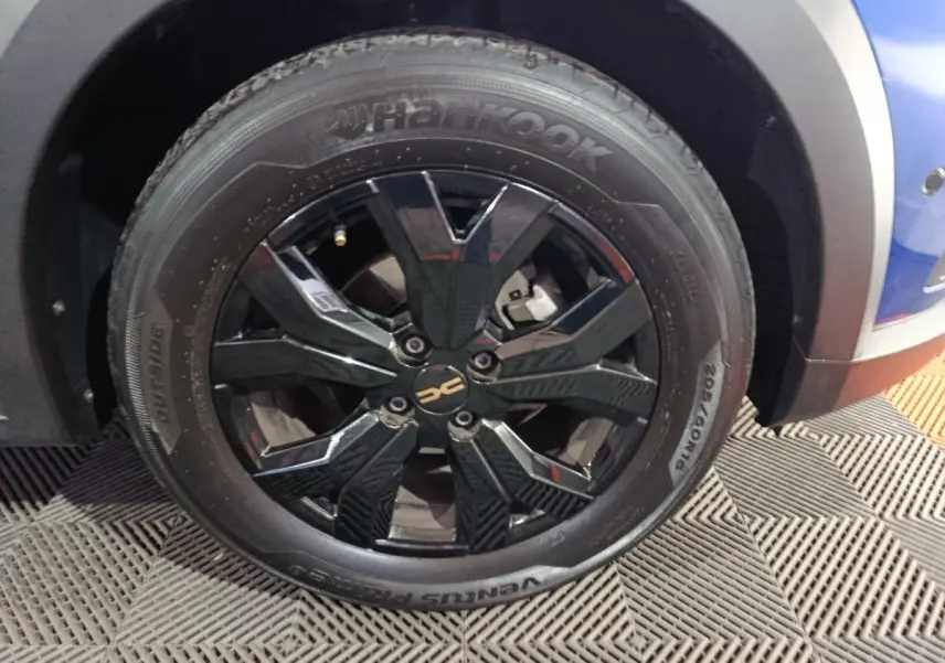 Gros plan sur la roue avant droite noire à jante alliage du Dacia Sandero Extreme+ bleu 2024.