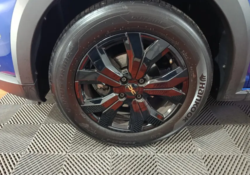 Gros plan sur la roue avant droite noire à jante alliage du Dacia Sandero Extreme+ bleu 2024.