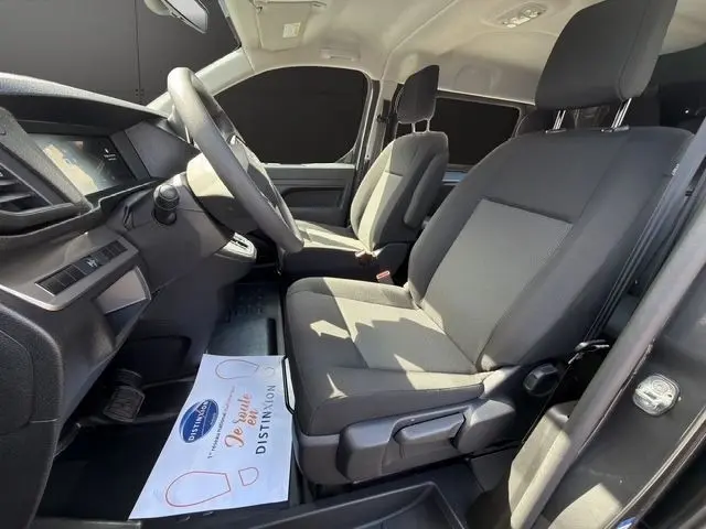 Vue intérieure côté conducteur du Citroën Jumpy gris foncé 2026, montrant les sièges avant et le volant multifonctions réglable.