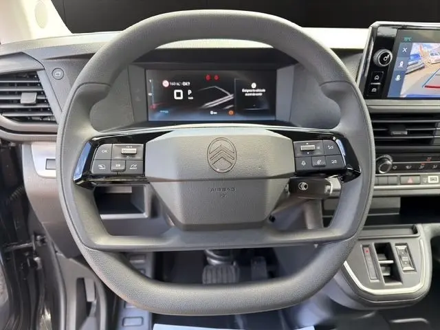 Vue centrée sur le volant multifonctions gris du Citroën Jumpy 2026 avec tableau de bord digital et écran tactile latéral.