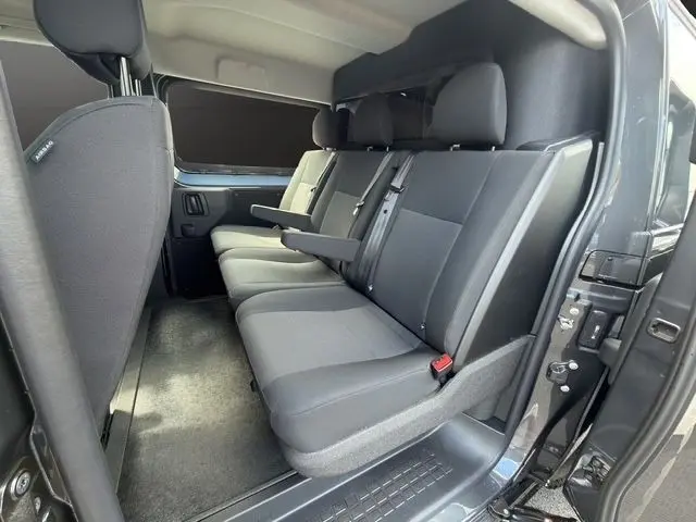 Vue intérieure côté droit sur la banquette arrière grise du Citroën Jumpy gris foncé avec cloison vitrée pleine.