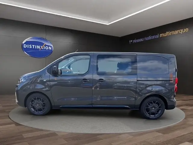 Vue latérale droite d'un Citroën Jumpy gris foncé 2026, fourgon utilitaire avec vitres latérales et jantes noires.