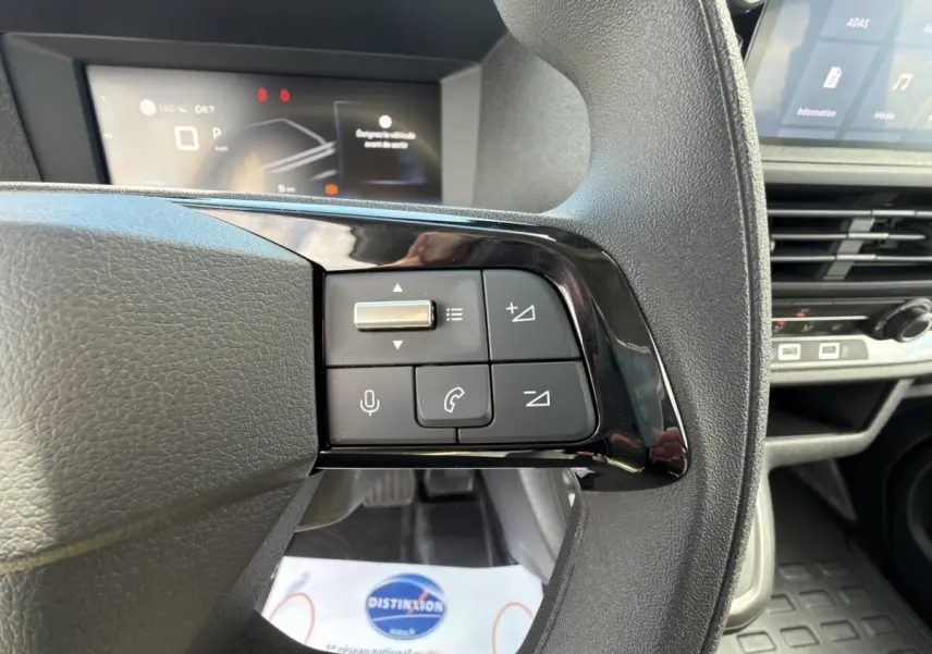 Gros plan sur les commandes du volant multifonctions noir du Citroën Jumpy 2026, intérieur moderne et écran digital en arrière-plan.