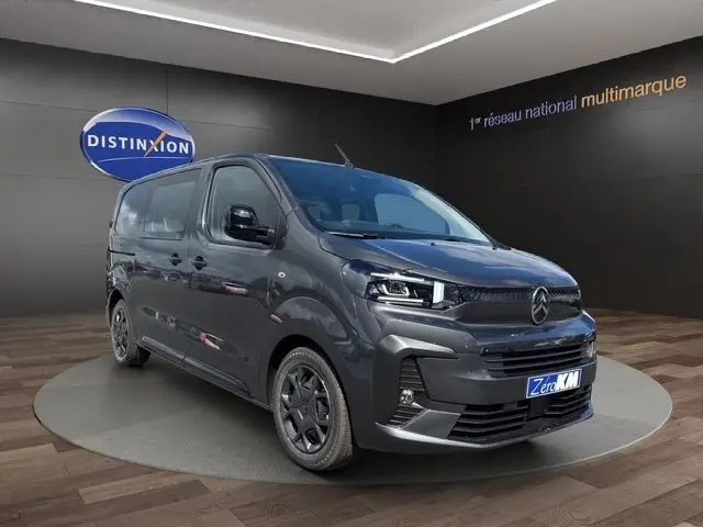 Vue 3/4 avant d'un Citroën Jumpy gris foncé 2026 en intérieur, avec calandre noire et jantes foncées distinctives.