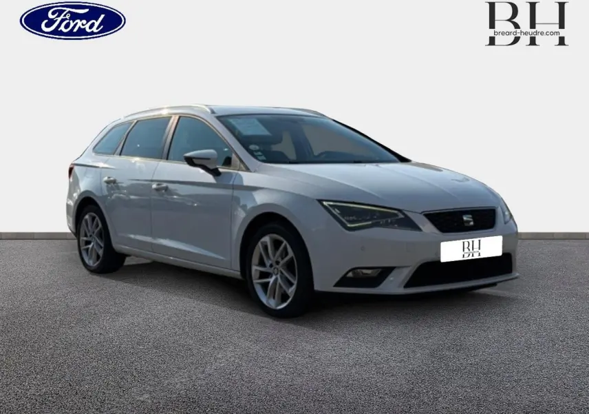 SEAT Leon ST gris étoile vue 3/4 avant droit, break compact avec jantes alliage et barres de toit visibles.