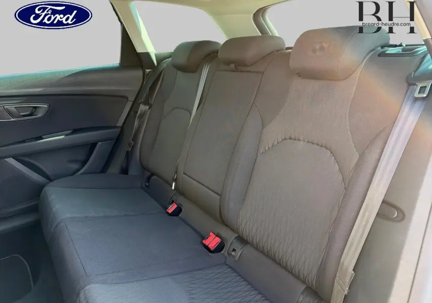 Vue intérieure du siège arrière en tissu gris d'une SEAT LEON ST 2017, avec ceintures de sécurité et appuie-têtes visibles.
