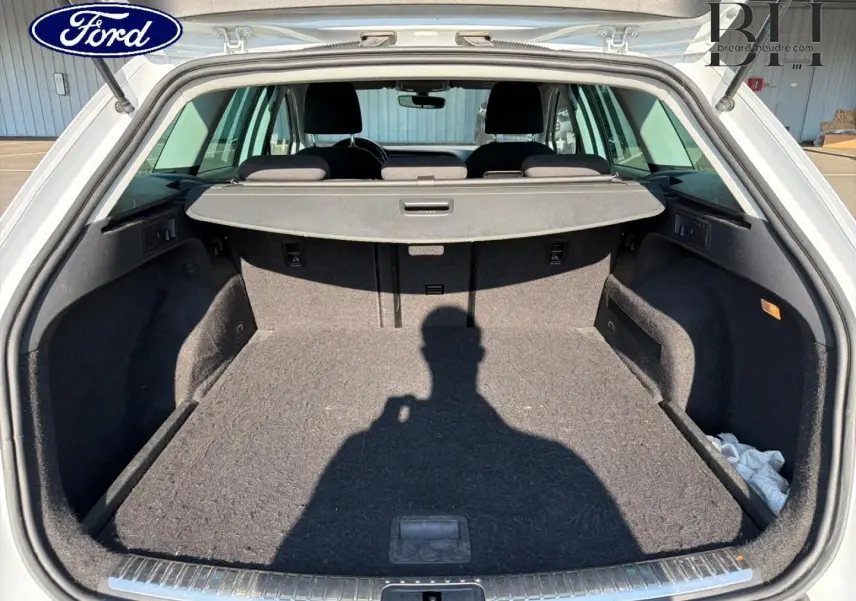 Coffre ouvert d’un SEAT LEON ST gris étoile, vue arrière montrant l’espace de chargement et la tablette cache-bagages.