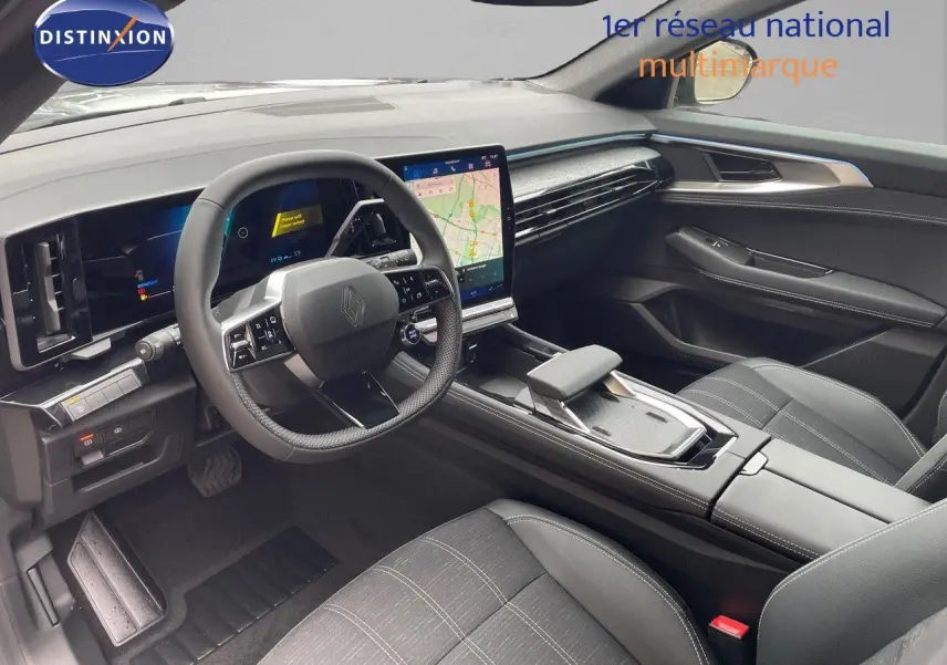 Intérieur avant droit du Renault Austral E-Tech gris, tableau de bord moderne avec écran tactile et volant multifonction.