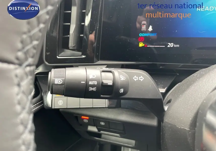 Gros plan sur la commande des phares et clignotants à gauche du volant dans le tableau de bord du Renault Austral gris schiste.