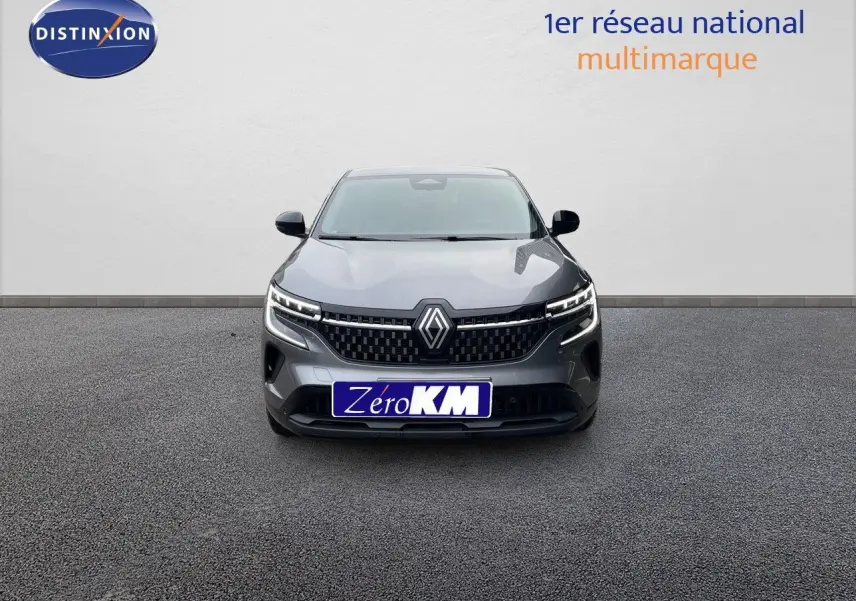 Vue frontale d'un Renault Austral gris schiste métal avec calandre noire et feux LED allumés sur fond neutre.