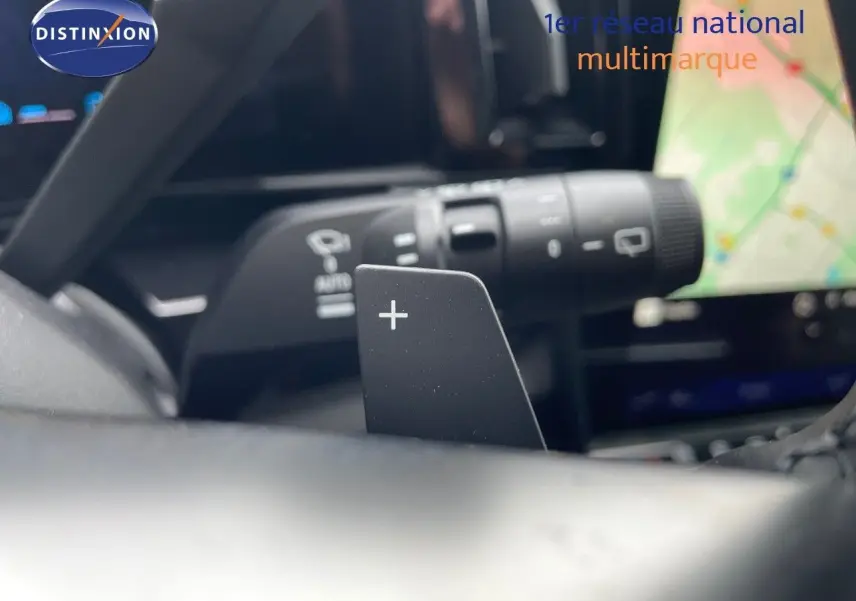 Gros plan sur la palette de changement de vitesse "+" du volant d'un Renault Austral gris schiste hybride 2025.