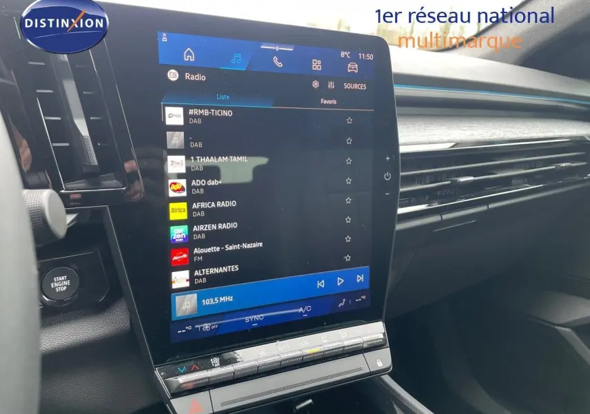 Écran tactile central du Renault Austral E-Tech gris schiste, avec affichage des stations radio en intérieur lumineux.