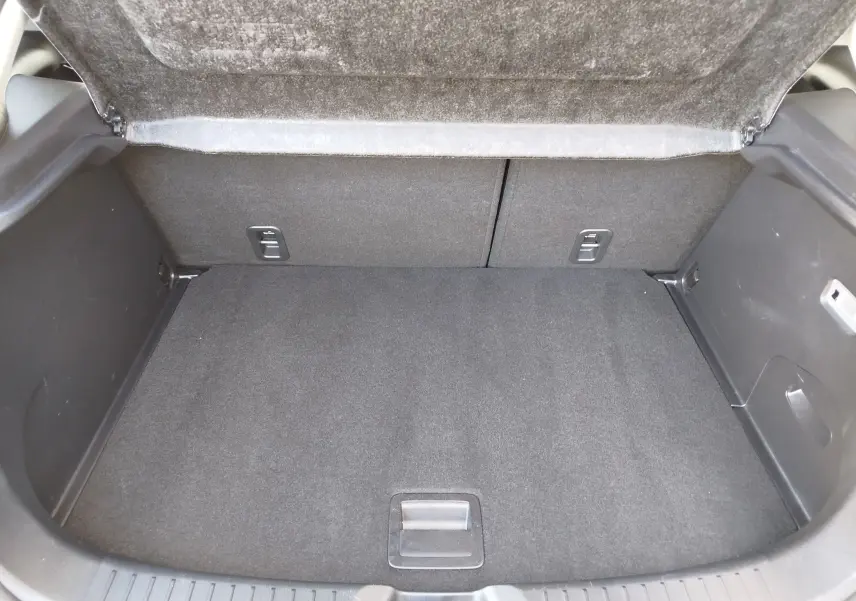 Coffre ouvert de la Mazda CX-3 2016 en bleu Dynamic Blue Mica, montrant un espace de rangement propre et bien fini.