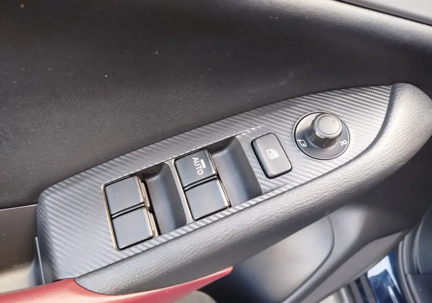 Gros plan sur la commande des vitres et rétroviseurs côté conducteur du Mazda CX-3 2016 en Dynamic Blue Mica.