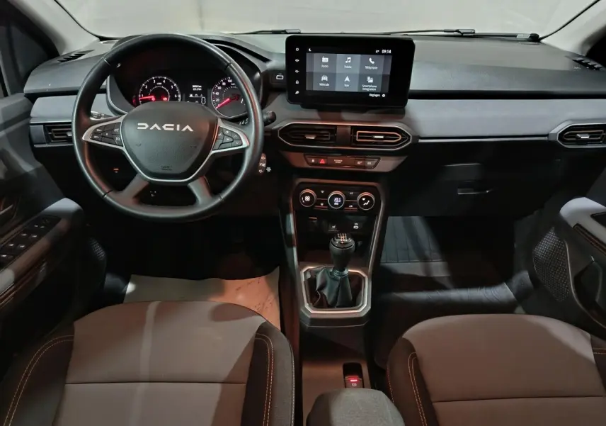 Vue intérieure avant du tableau de bord de la Dacia Sandero Extreme+ 2024 avec volant cuir multifonctions et écran tactile central.