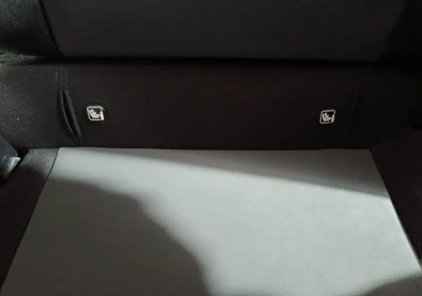 Vue rapprochée du coffre noir de la Dacia Sandero 2024, montrant les fixations Isofix sur la banquette arrière.