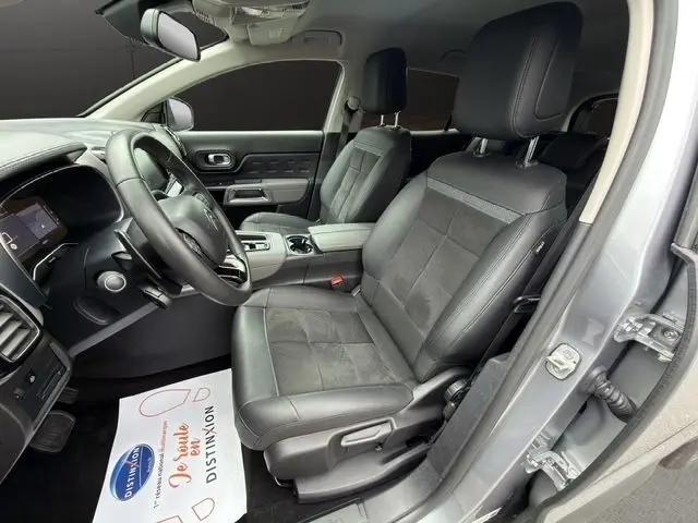 Vue intérieure côté conducteur du Citroën C5 Aircross gris clair, sièges cuir noirs et volant multifonctions.