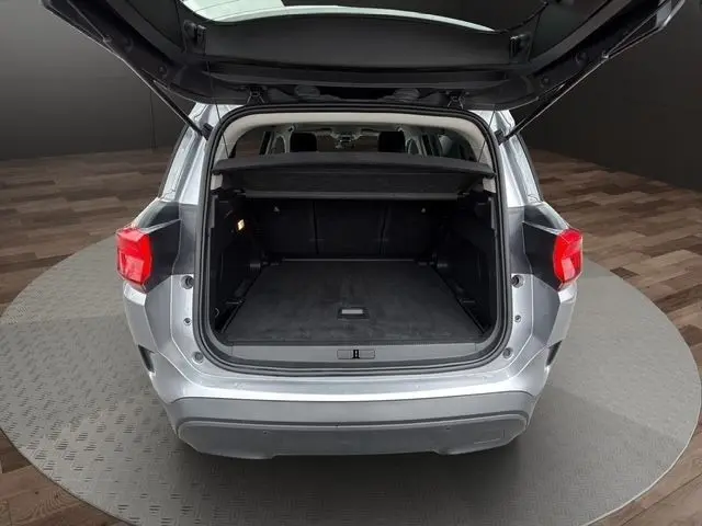 Vue arrière ouverte du coffre d’un Citroën C5 Aircross gris clair 2022, montrant l’espace de chargement vide.