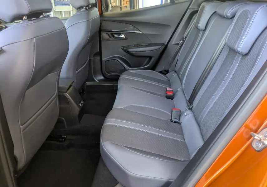 Vue intérieure côté droit des sièges arrière gris du Peugeot 2008 orange, mettant en valeur l'espace et les finitions.
