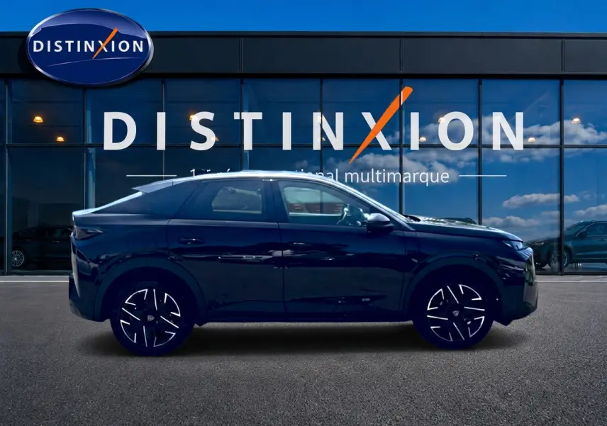 Peugeot 3008 noir en profil droit, avec jantes alu distinctives, devant une vitrine de concession multimarque.